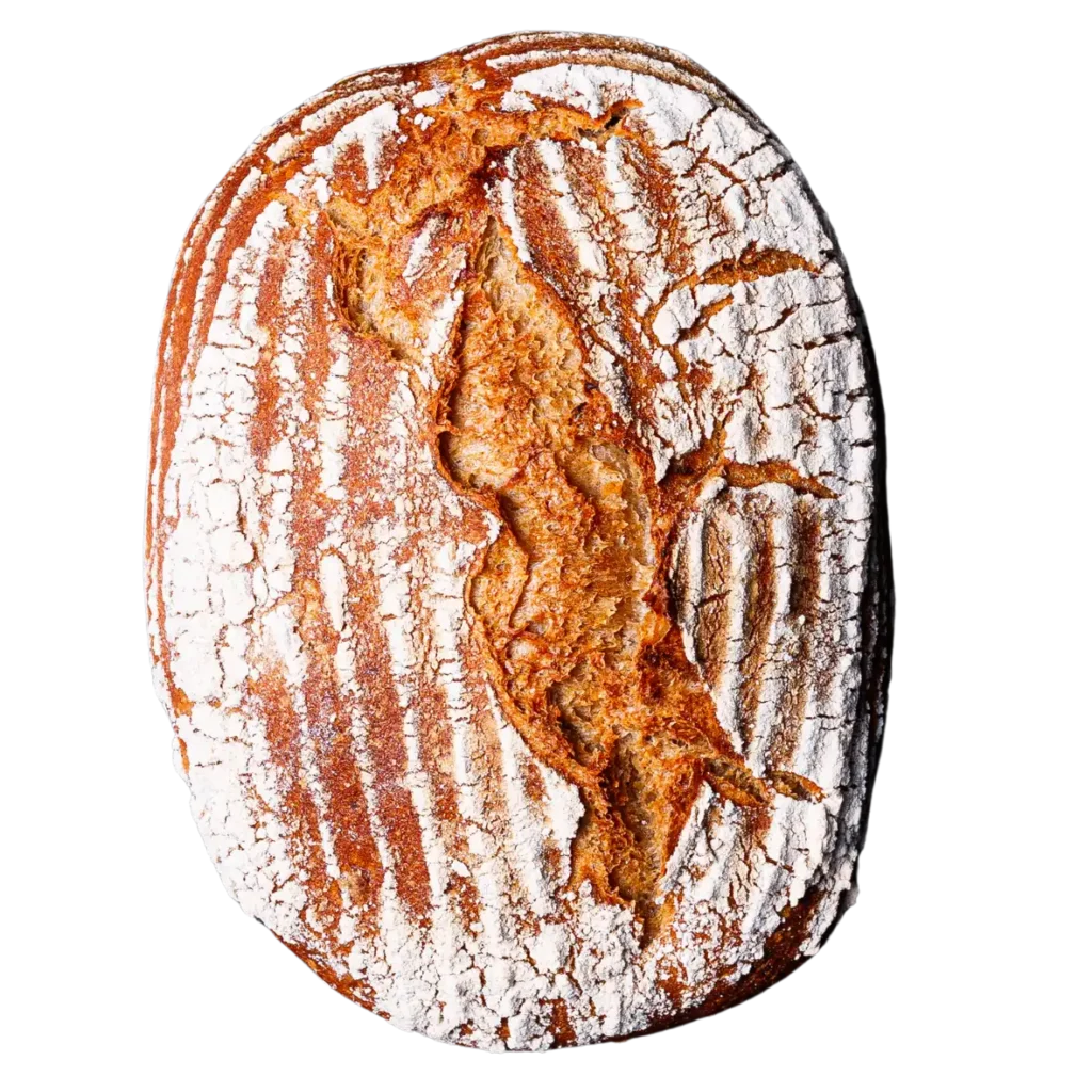 Ein rustikales, ovales Brot aus der Bäckerei Wiesender in Pfaffenhofen mit einer goldbraunen Kruste, einem tiefen Riss in der Mitte und einer Bestäubung mit Weißmehl, die die für die Naturbackstube typischen Rillenmuster des Gärkorbs hervorhebt.