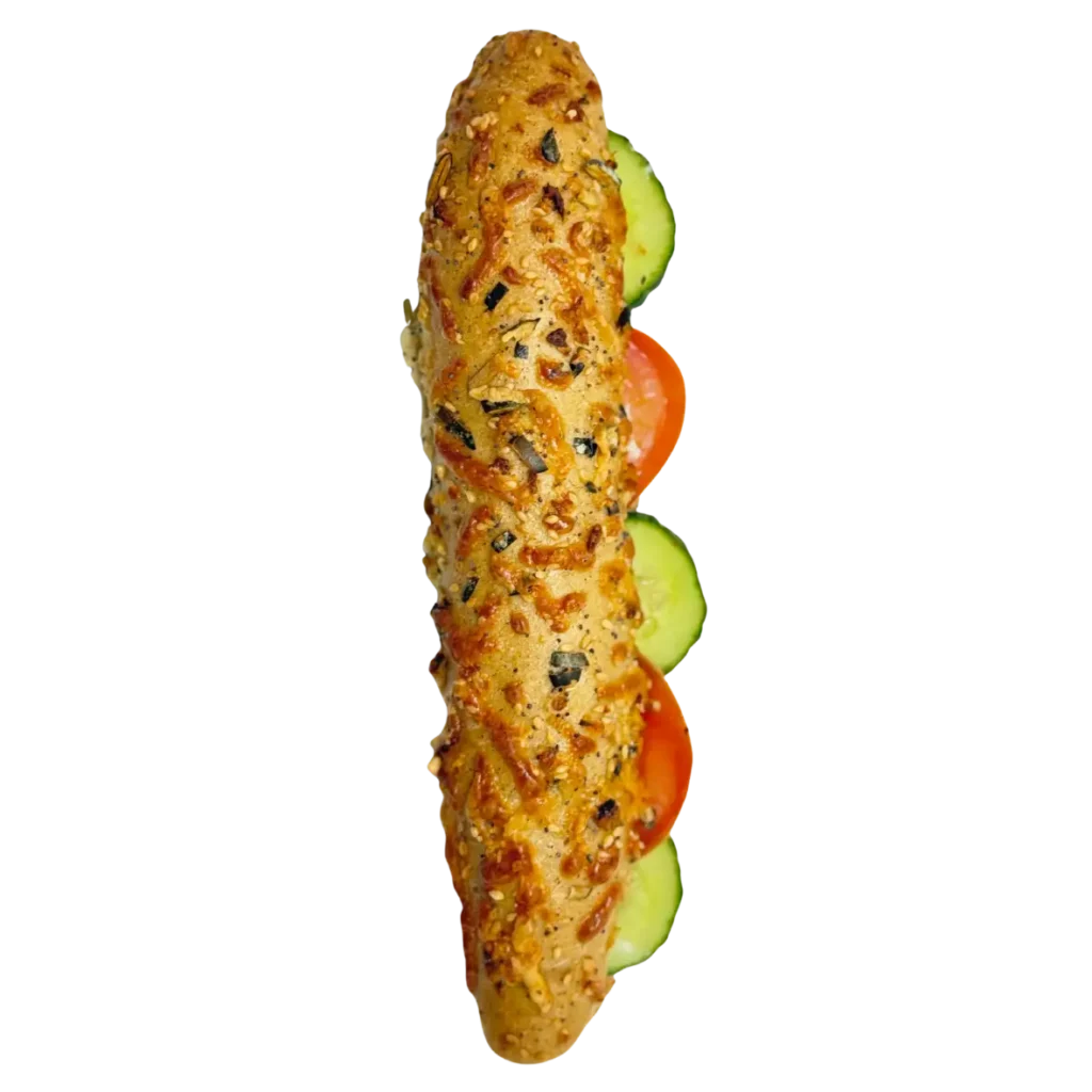 Ein Sandwich auf einem entkernten Baguette, hier von der Seite, gefüllt mit Tomaten- und Gurkenscheiben - perfekt für ein frisches Mittagessen in Freising.