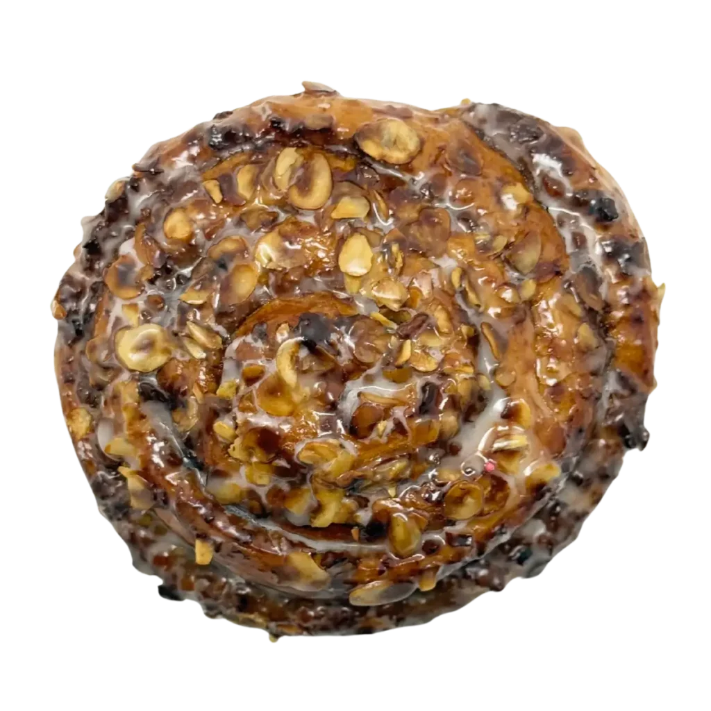 Eine Nahaufnahme einer glasierten Zimtrolle der Bäckerei Wiesender, die mit Haferflocken belegt und spiralförmig angeordnet ist - eine köstliche Spezialität aus Moosburg und Pfaffenhofen.