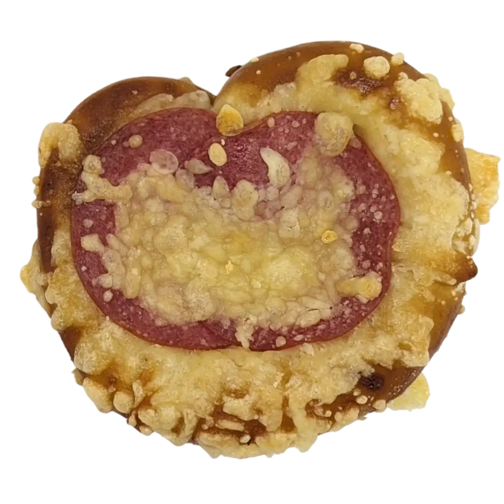 Ein herzförmiges Gebäck der Bäckerei Wiesender in Freising, belegt mit geschmolzenem Käse und einer großen Scheibe Salami in der Mitte, zeigt die Handwerkskunst dieser renommierten Naturbackstube.