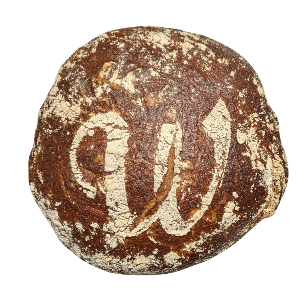 Ein runder Laib dunkelbraunes Brot aus der Naturbackstube mit rustikaler, knuspriger Oberfläche und sichtbaren Rissen, isoliert auf weißem Hintergrund - eine Reminiszenz an die handwerkliche Tradition von Moosburg und Pfaffenhofen.